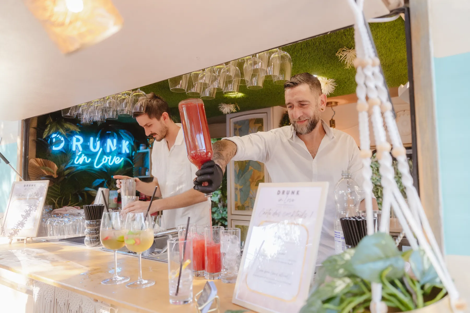 Deux barmen derrière le bar au néon bleu