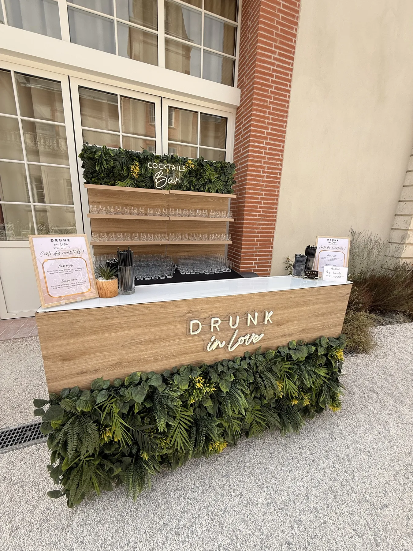 Bar à cocktails en bois installé dans une cour, mur végétal