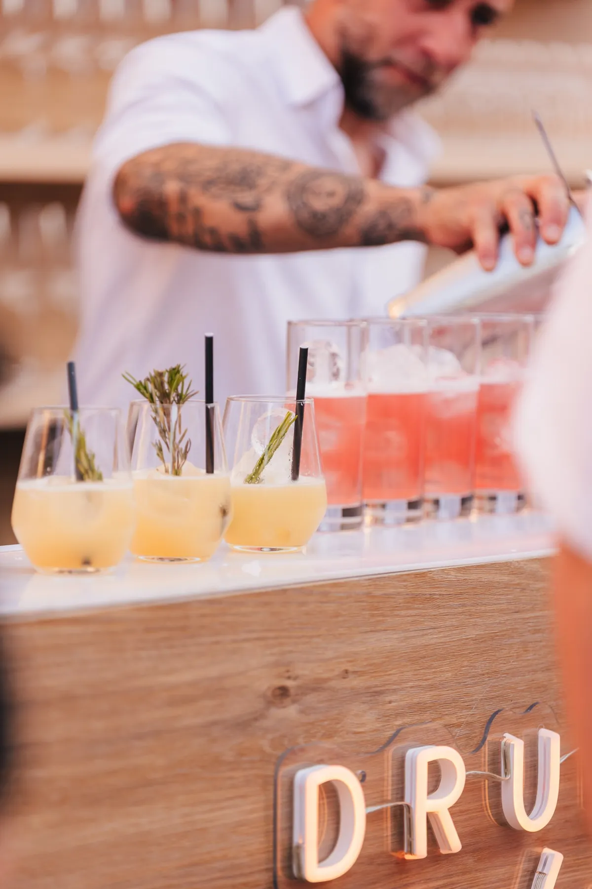 Barman en plein service devant des cocktails colorés