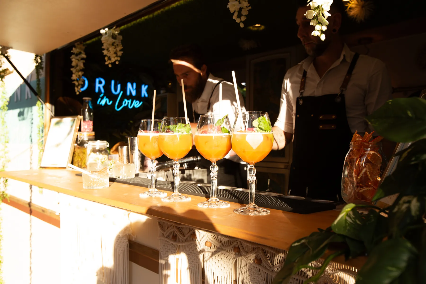 Cinq spritz alignés devant le néon Drunk in Love