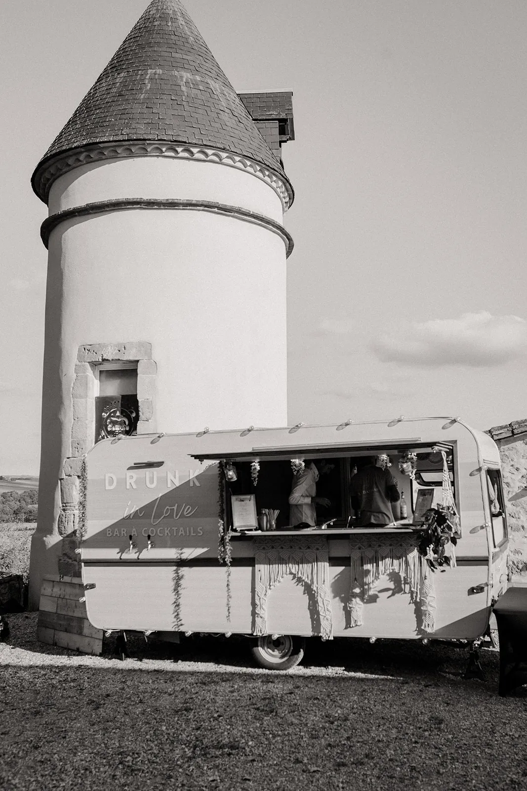 Caravane bar devant une tour, en noir et blanc